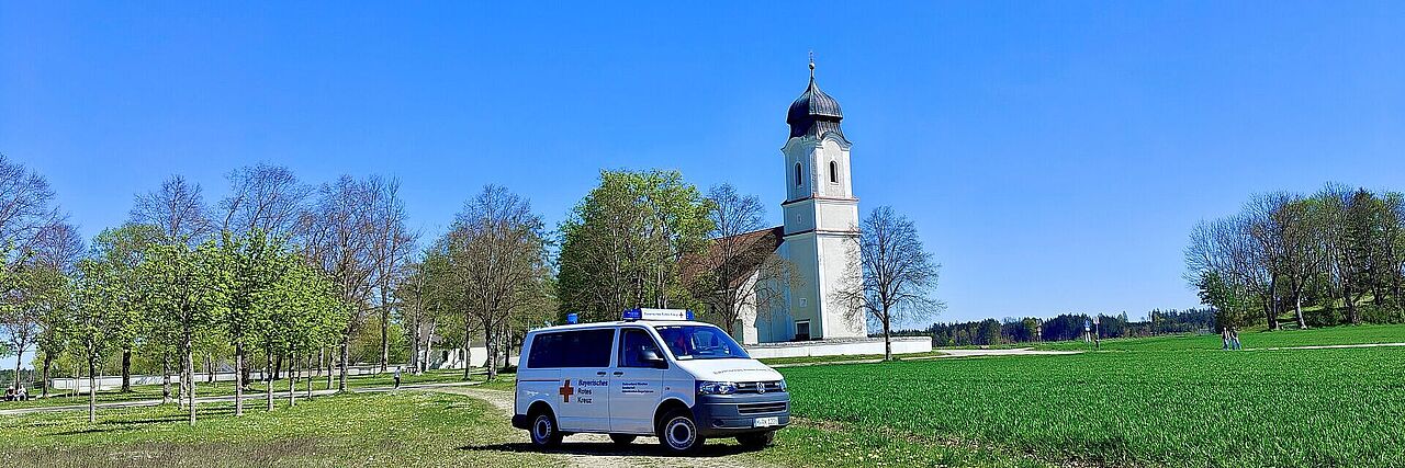 BRK Mannschaftstransportwagen auf der Wiese vor der Leonhardikirche in Siegertsbrunn.
